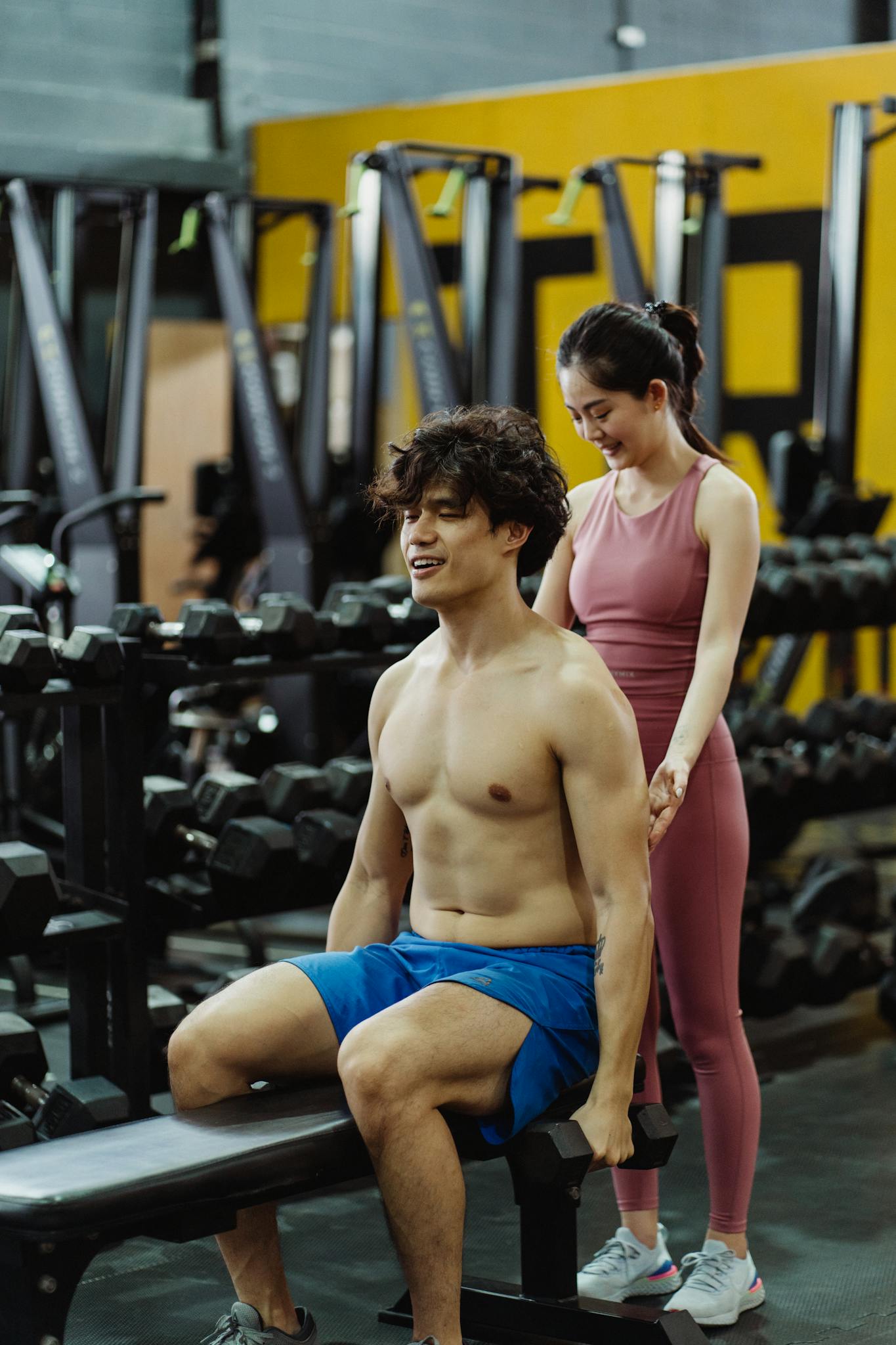 Man and woman in a gym engaged in a personal training session, focusing on fitness and health.